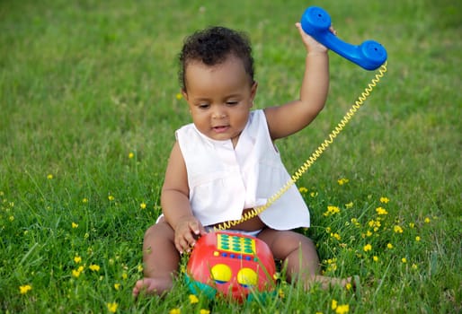 Adorable little black girl with big phone