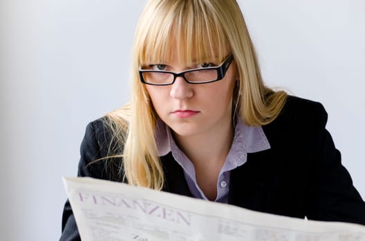 Young woman reading bad news in a newspaper