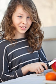 Cute teen girl cutting in the kitchen and cutting an apple with a knife