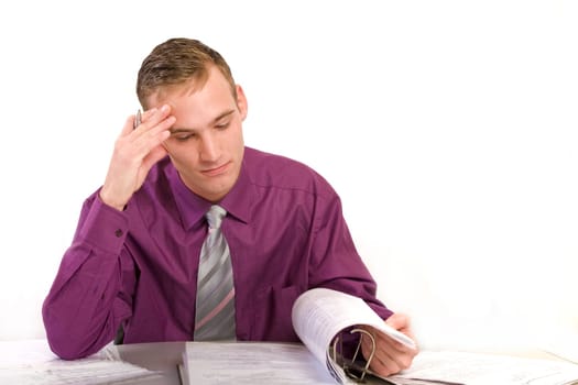 Businessman in office at desk thinking. He looks anxiously at a file folder.