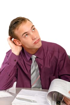 Businessman in office at desk thinking. He looks up and thinks about a file folder in front of him.