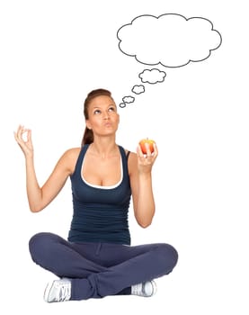 Gymnastics girl thinking with an apple sitting with cross-legs on white background