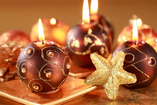 Christmas still life with candles and jingle bells in brown and golden tone