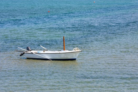 Lonely wooden fishing rowboat on the sea