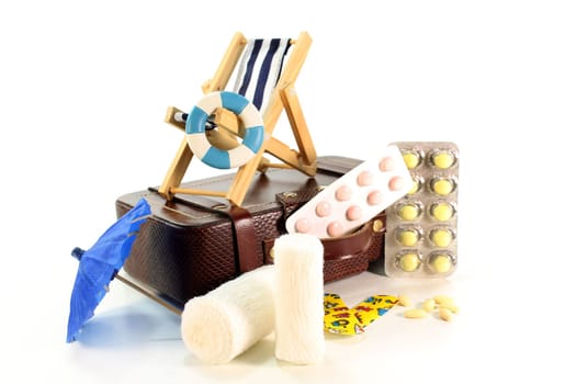Medicines and suitcases in front of white background