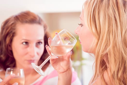 two women drinking wine in living room