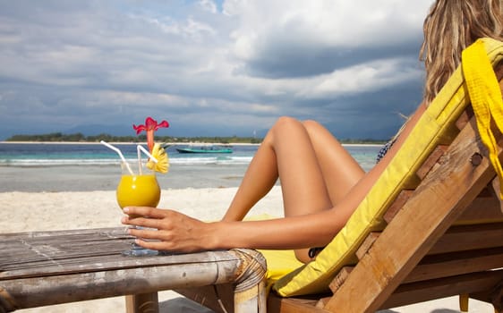 Woman enjoying a cocktail on a tropical beach