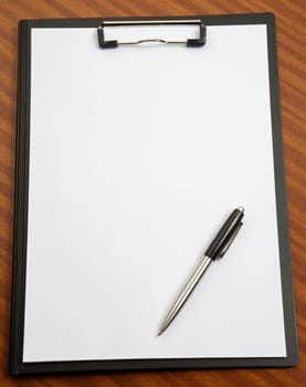 Clipboard and pend a over wood background