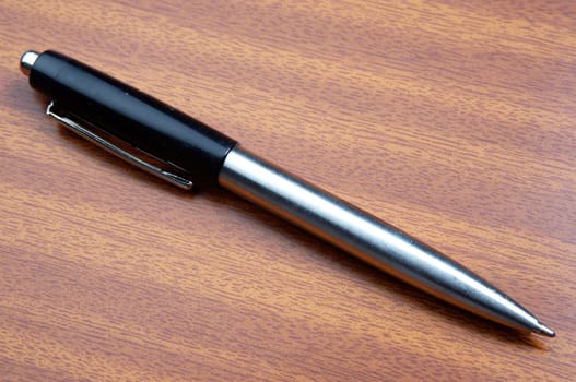 a photo of a pen a over wood background