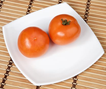 a photo of two tomatoes in a white plate