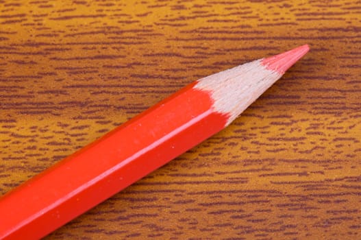 a photo of a red pencil on the wood background