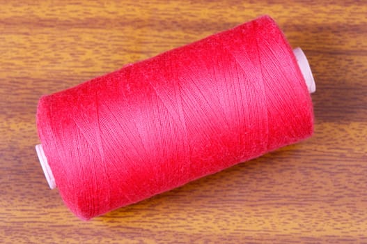 Detail of thread in a coil a over wood background