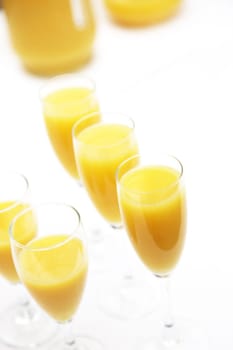 Many glasses of fresh orange juice in a row with copy space