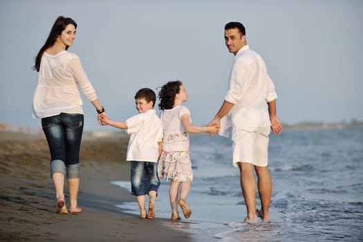 happy young family have fun and live healthy lifestyle on beach