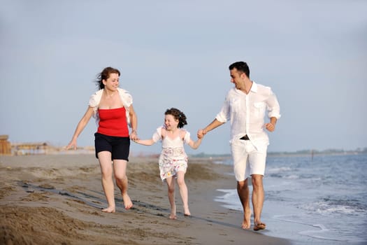 happy young family have fun and live healthy lifestyle on beach