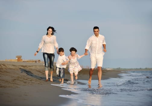 happy young family have fun and live healthy lifestyle on beach