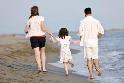 happy young family have fun and live healthy lifestyle on beach