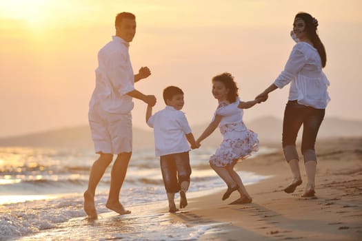 happy young family have fun and live healthy lifestyle on beach