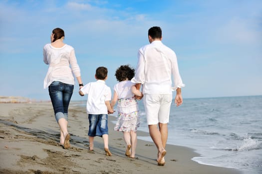 happy young family have fun and live healthy lifestyle on beach