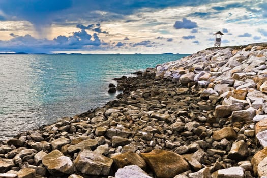 Lighthouse jutting out into the sea.