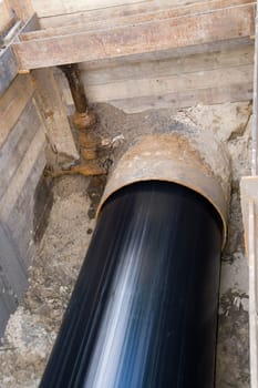 New laying of a water supply pipeline using the pull-in method. Here,a new plastic pipe (1000 mm) and an old steel pipe are pulled in trenchlessly. View of the excavation pit in the direction of the catchment in Berlin.