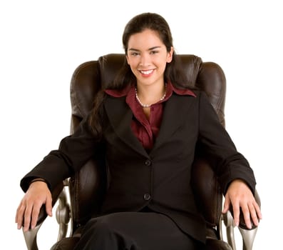 A smiling businesswoman is sitting on a leather chair.