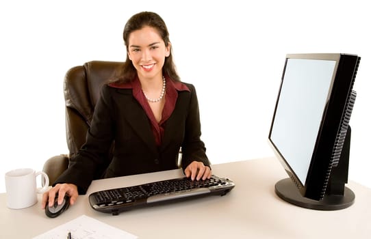 Beautiful businesswoman is sitting at her desk and smiling at the camera.