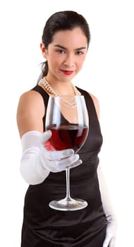 A beautiful woman in a classy dress is serving a glass of red wine.