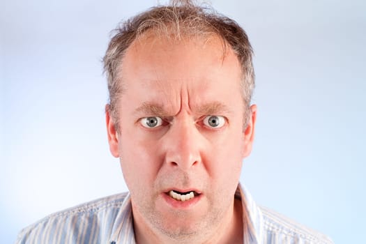 A man looking at the camera is angry about something.