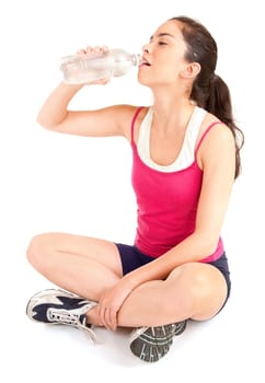 A woman is drinking water from a bottle after a workout.