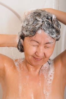 Asian woman showering and washing her hair with shampoo