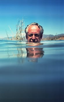 Man&#039 s head in a lake just above water