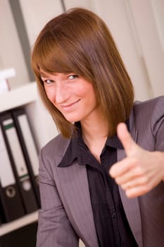 woman in business suit with thumb up by office work