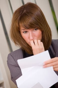 shocked business woman reading a letter with bad news
