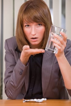 stressed business woman with headache taking pills