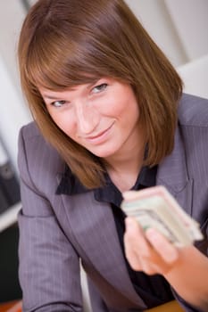 woman with stack of money - giving bribe or success business