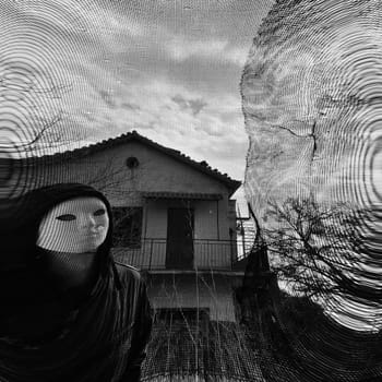 Masked figure behind threaded window. Black and white.