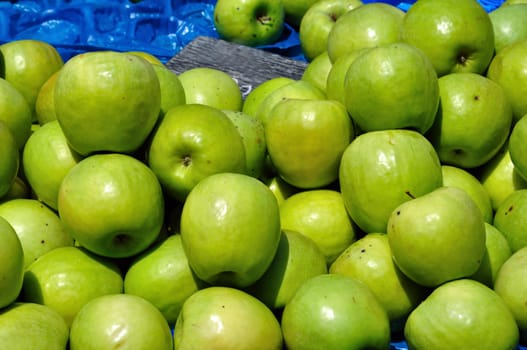 Green apples for sale at grocery store. Fruit background.