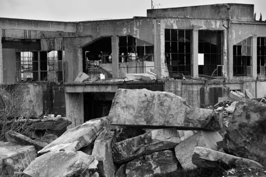 Abandoned marble processing factory and pile of granite slates. Black and white.