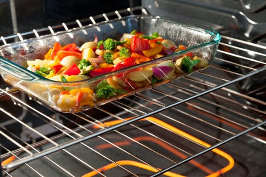 Fresh vegetables roasting in a clear dish in the oven