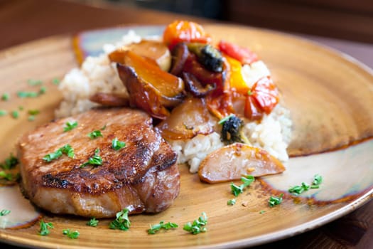 Dinner plate of pork, rice, and roasted vegetables