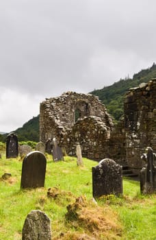 Cathedral ruins at Glendalough (Gleann Da Loch) National Heritage Center in Ireland. View over the ancient cemetery and Wicklow mountains.