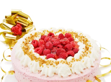 Festive raspberry cake for the celebration of birthdays or anniversaries. With golden bow and red heart decorations. Isolated on white.