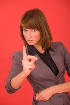 business woman pointing with finger over red background