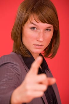 upset woman pointing with finger over red background