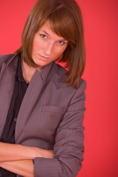 woman in formal grey suit posing over red background