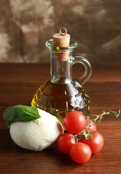 mozzarella with tomatoes, oil and basil on wood table