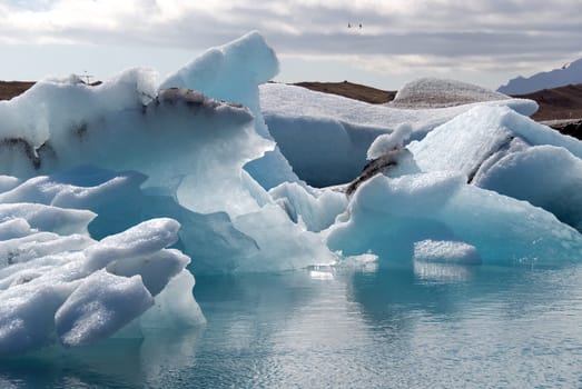 Iceberg reflections on the calm water of the lake Jokulsarlon