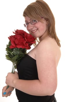 Smiling teenager holding a bunch of red roses to her chest, smiling into the  camera, in closeup and with glasses, for white background.