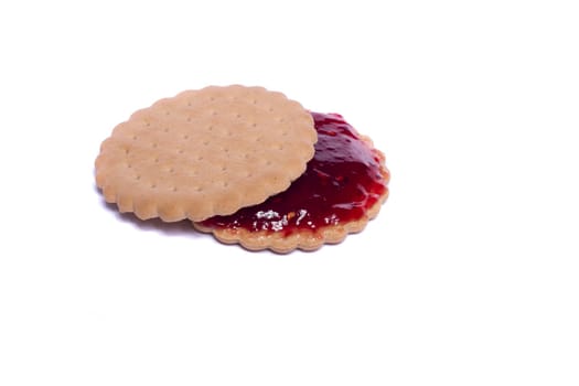 View of a round biscuit isolated on a white background with berry jam.